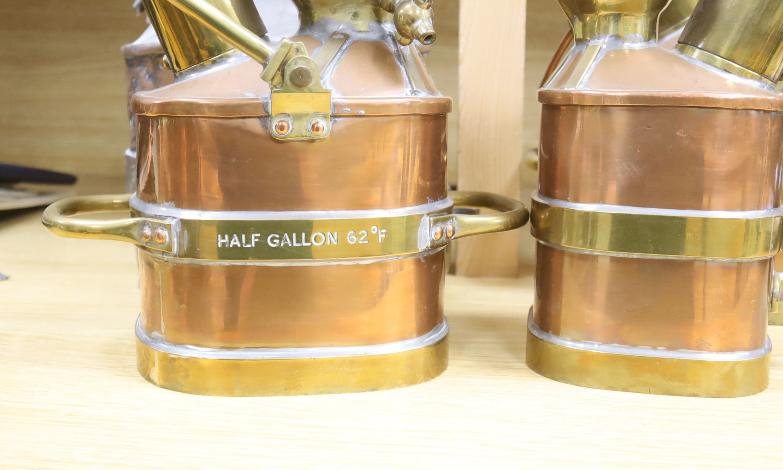 A group of four copper and brass mounted checkpumps, from quart size to one gallon, largest 28cm